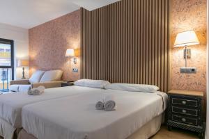 Habitación de hotel con 2 camas y toallas. en H-A Aparthotel Hotel Quo, en Madrid