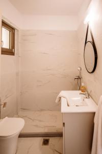 a white bathroom with a sink and a shower at Nadia Apartments B in Kalamaki