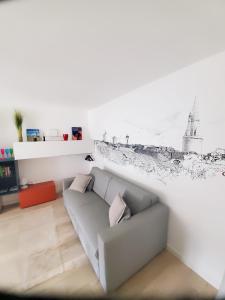 a living room with a couch with a drawing on the wall at Les Saints Pères in La Rochelle