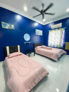 two beds in a blue room with a ceiling fan at DF ZaheenulFitri Homestay (Muslim Homestay) in Seremban