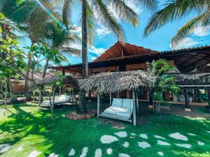 a resort with a hammock and palm trees at El Sitio Village in Playa Venao