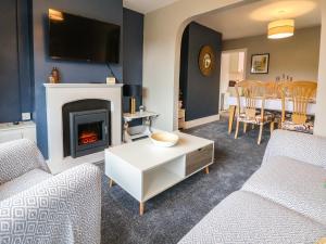 a living room with two couches and a fireplace at Gables Cottage in Northwich