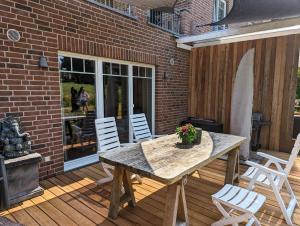 eine Terrasse mit einem Tisch und Stühlen auf einer Holzterrasse in der Unterkunft Ferienwohnung Seestern in Reinbek in Reinbek