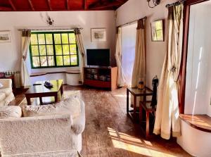 ein Wohnzimmer mit einem Sofa und einem TV in der Unterkunft Spacious characterful villa with spectacular views in quiet rural setting. in Breña Alta