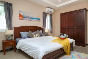 CityHouse-OSCAR,pool villa 4Bedrooms-Jacuzzi-walking Street 10min في جنوب باتايا: غرفة نوم بسرير كبير مع شراشف بيضاء