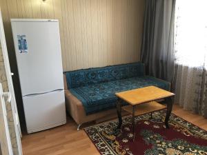 a room with a couch and a refrigerator and a table at Эдем in Cholpon-Ata