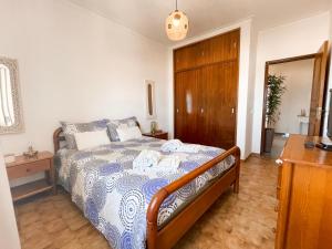 a bedroom with a bed with a blue and white comforter at Apartamento T1, Praia da Rocha - Edificio Mar Azul in Portimão