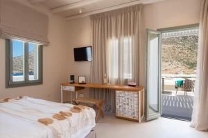 Schlafzimmer mit einem Bett, einem Schreibtisch und einem Balkon in der Unterkunft Sunlight in Kamarai