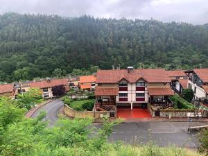 a building with a road in front of a mountain at Casa con terraza para 4 personas en Plentzia in Mendiondo