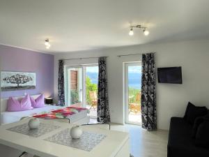 a bedroom with a bed and a living room with a window at Apartments Gajeta in Povile