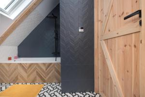 a bathroom with a shower with a black wall at Apartament Wincentego Styczyńskiego in Gliwice