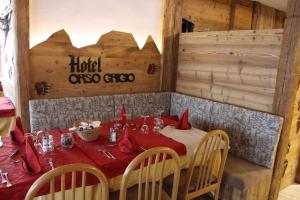 jadalnia ze stołem i czerwoną tkaniną w obiekcie Hotel Orso Grigio w mieście Carisolo