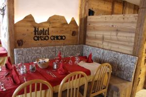 a dining room with a table with a red table cloth at Hotel Orso Grigio in Carisolo