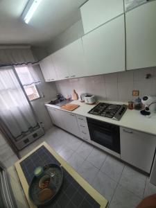 Una cocina con gabinetes blancos y un horno de estufa. en Marina Apartments - Playas, en Santa Pola 5 fotos más