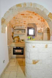 - une cuisine avec une arche en pierre et une cuisinière dans l'établissement VERDEACQUA HOUSE, à Locorotondo