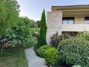 a garden in front of a house with trees and bushes at Nature & Design in Bonifacio