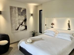 a bedroom with a large white bed with a hat on it at Nature & Design in Bonifacio