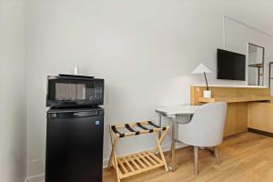 uma cozinha com uma pequena mesa e um micro-ondas em cima de um frigorífico em Hotel Manteo em Manteo