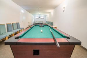 a pool table in a room with chairs at Regia Panzió in Halászi