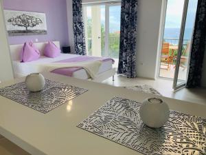 a bedroom with a bed and a table with two vases at Apartments Gajeta in Povile