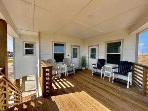 パドレ・アイランドにあるCasa Pura Vidaの椅子とテーブル付きのポーチ、窓