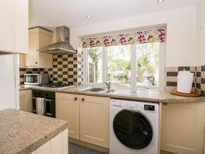 a kitchen with a washing machine and a window at The Annexe in Soutergate