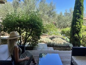 a woman in a hat sitting on a bench looking at a garden at Nature & Design in Bonifacio