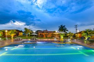 a large swimming pool in a resort at night at Cabitat Cabañas in Quimbaya