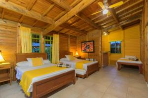 um quarto com 2 camas num chalé de madeira em Cabitat Cabañas em Quimbaya