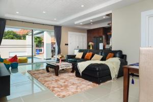sala de estar con sofá de cuero negro y mesa en CityHouse-OSCAR,pool villa 4Bedrooms-Jacuzzi-walking Street 10min en Pattaya South