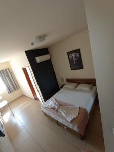 a bedroom with a large bed and two windows at Sallimas Hotel in Sorocaba