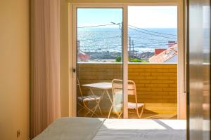 1 dormitorio con cama y vistas al océano en Portugal Active Moledo Beach House, en Moledo