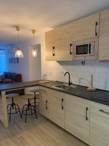 uma cozinha com um lavatório e um micro-ondas em Ideal apartamento en el Barrio de las Delicias em Málaga
