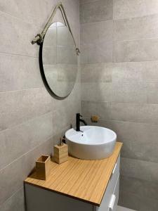uma casa de banho com um lavatório branco e um espelho. em Ideal apartamento en el Barrio de las Delicias em Málaga