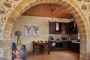 a kitchen with an archway and a table in a room at Batilas Garden House in Kissamos