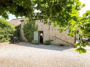 een stenen gebouw met een deur en een kruk bij Shippon Cottage in Castleton
