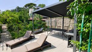 d'une terrasse avec une table, des chaises et un auvent noir. dans l'établissement Aparatman Residence, à Rijeka