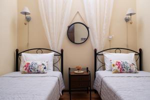 two beds in a bedroom with a mirror on the wall at Batilas Garden House in Kissamos