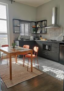 a kitchen with a wooden table and a dining room at Little Garden private pool villa in Al Ḩamrāʼ