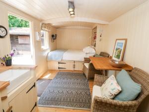 a tiny house with a kitchen and a bedroom at Shepherd's Hut in Castleton