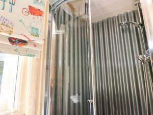 a shower with gray curtains in a bathroom at Shepherd's Hut in Castleton