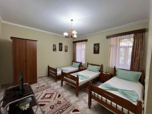 a room with two beds and a piano in it at Guest House Adi Doga in Berat