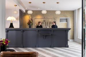 two women sitting at a bar in a hotel lobby at Hôtel Madeleine Plaza in Paris