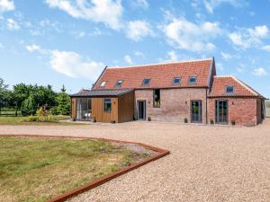 a brick house with a red roof on a gravel driveway at The Roost - Uk42856 in Rise