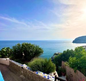 een uitzicht op de oceaan vanuit een stenen muur bij Casa Assunta in Ischia