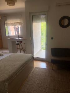sypialnia z łóżkiem i przesuwnymi szklanymi drzwiami w obiekcie Apartman Val w mieście Zadar