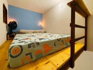 a bedroom with a bed with a colorful blanket at Hospedagem Sabor Da Trilha in Vale do Capao