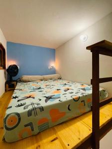 a bedroom with a bed with a colorful comforter at Hospedagem Sabor Da Trilha in Vale do Capao