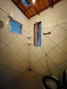 a bathroom with a shower with a toilet and a window at Hospedagem Sabor Da Trilha in Vale do Capao