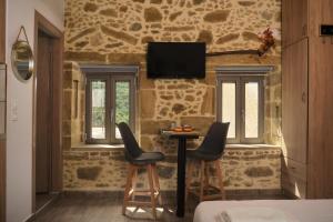 a room with two chairs and a table with a tv on the wall at Studio Batilas in Kaláthenai